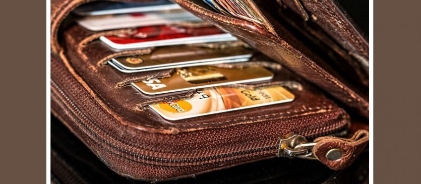 A brown leather wallet with credit cards in it.
