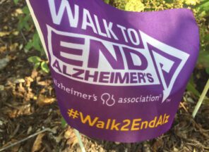 A purple flag with the words walk to end alzheimer's.